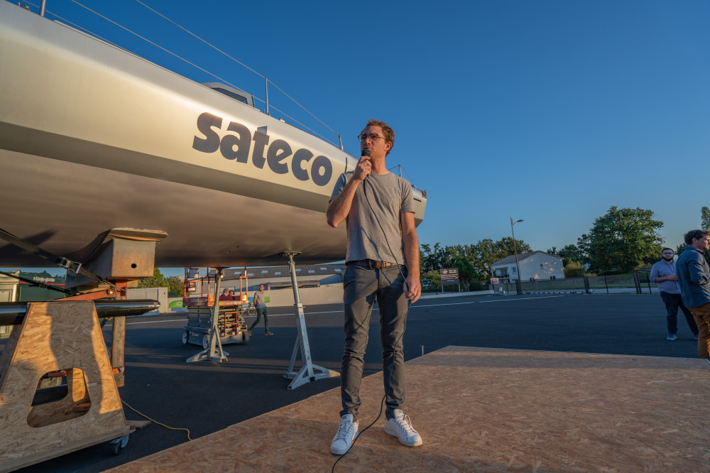 Le skipper Benjamin Dutreux devant son nouveau bateau sponsorisé par Sateco, l'Imoca 60